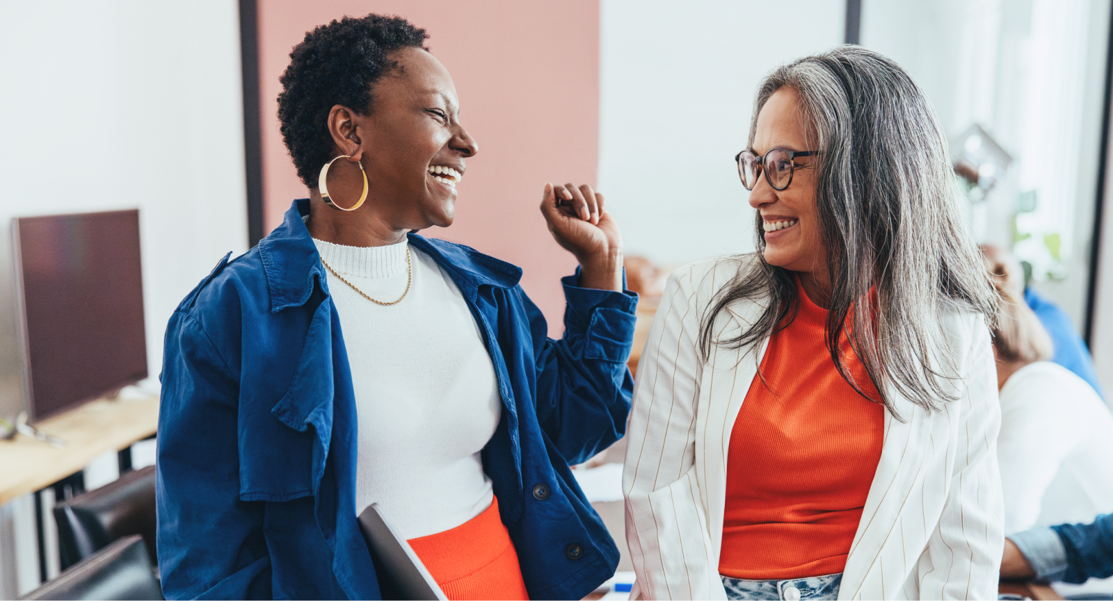 Two excited businesswomen in an office.