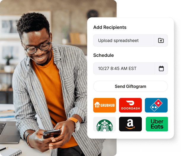 Smiling man uses Giftogram sending screen to bulk schedule gift cards from diverse brands for employee recognition.
