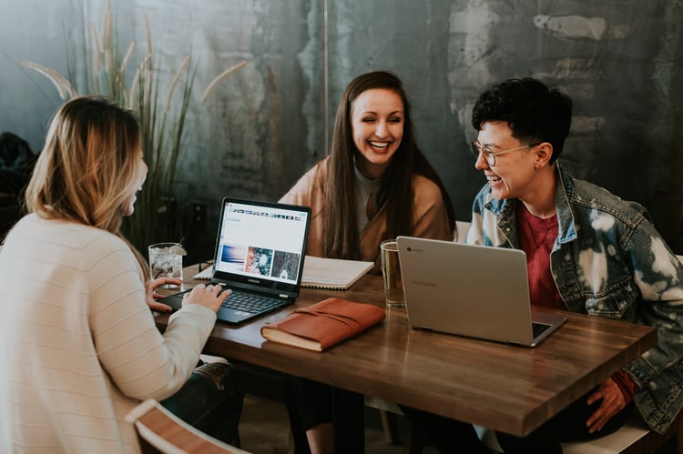 Millennial female employees gathering in a collaborative workspace