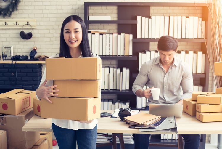 Woman holding boxes to ship to customers