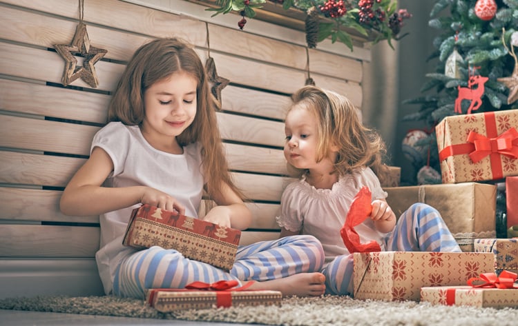 Children opening gifts purchased with buy one get one consumer incentives