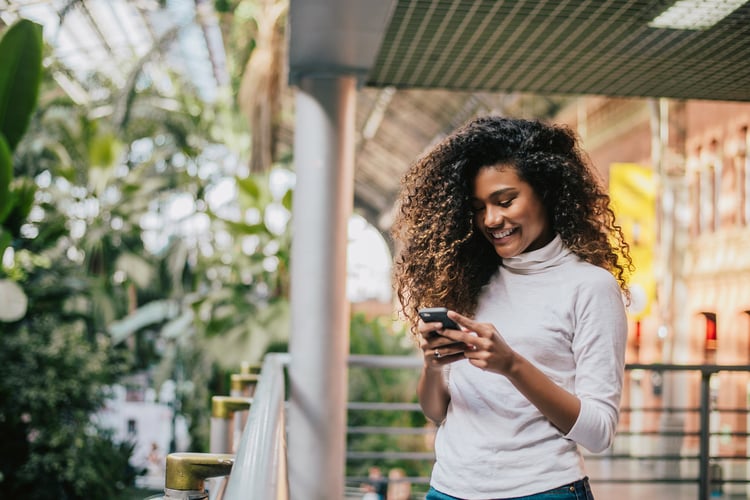 A woman leaving customer reviews from her mobile phone