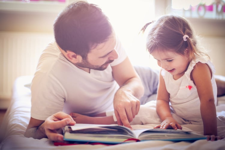 A parent with flexible working hours reading to his daughter