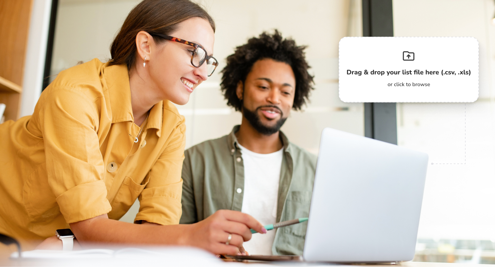 Coworkers smiling at computer in office setting